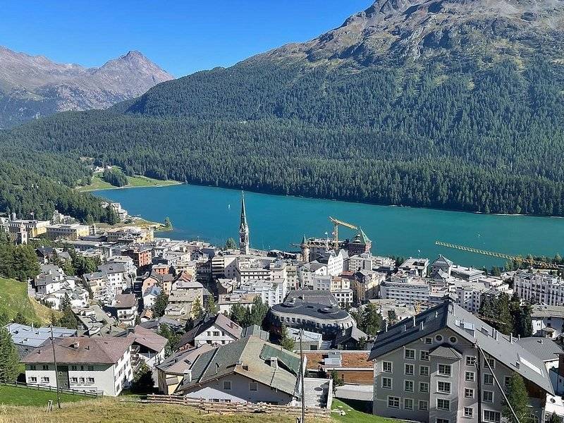 A resort town on the shore of a blue lake in a high valley ringed by forest