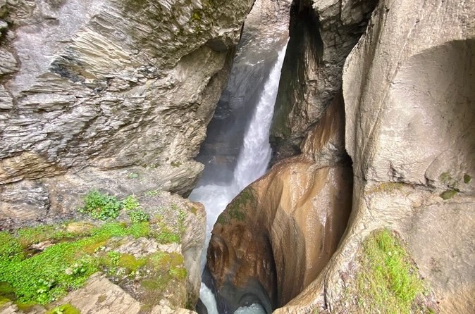 A waterfall pouring through a smooth channel it has carved into the rock